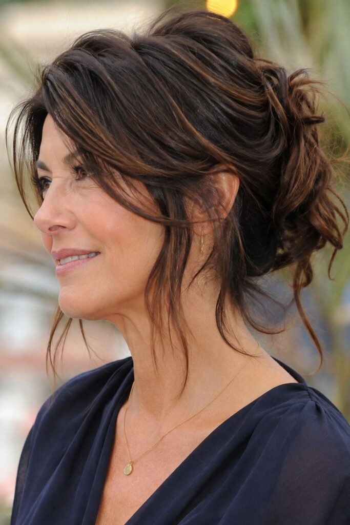 Long layered hair styled in a loose updo with face-framing pieces