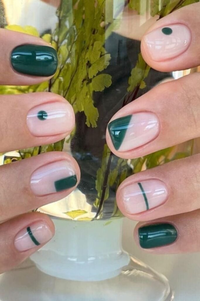 Negative-space nails with forest green geometric shapes