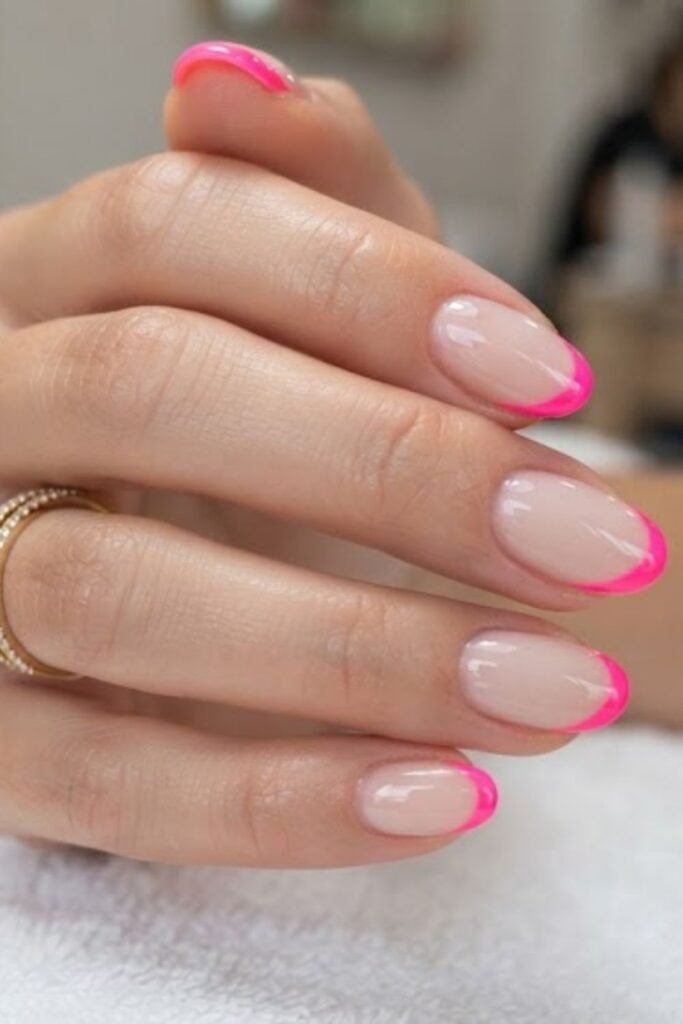 Neon French tip nails on a sheer nude base