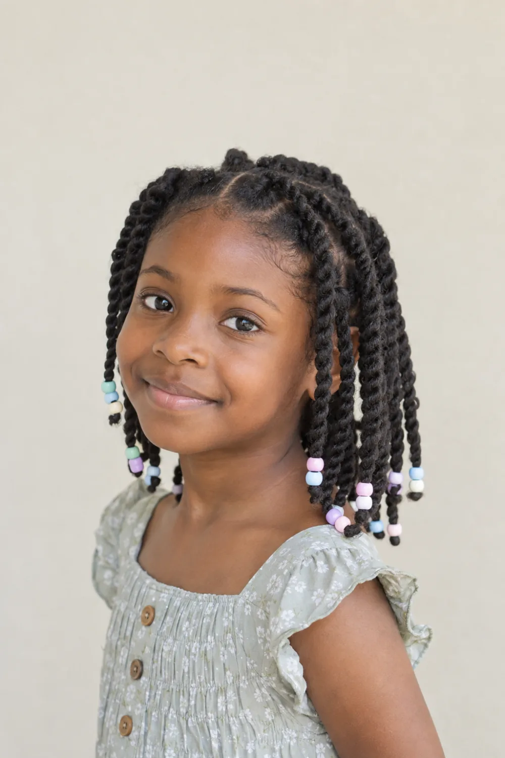 Medium two-strand twists with pastel beads on a Black child