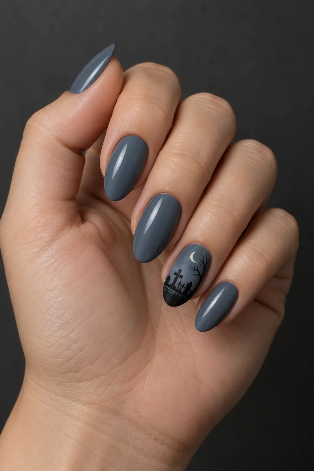 Dusky gray-blue nails with a graveyard silhouette and crescent moon accent
