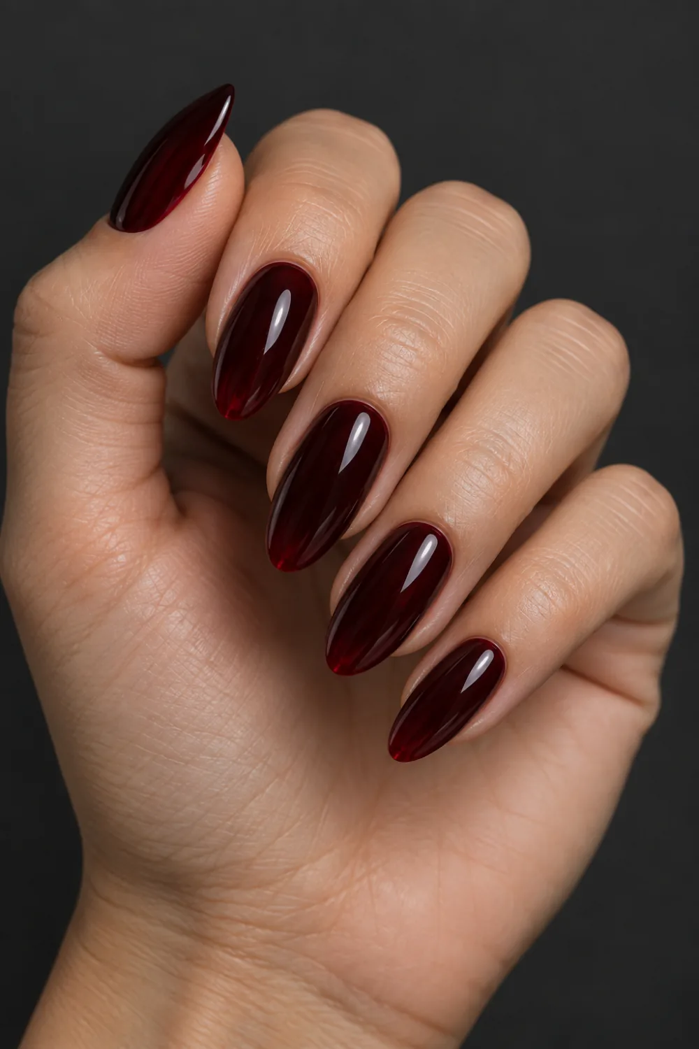 Glossy black-cherry jelly nails with translucent red depth