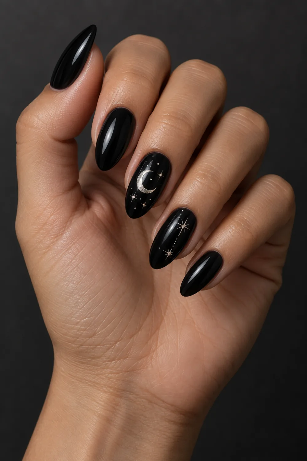 Glossy black nails with small silver moon and star accents