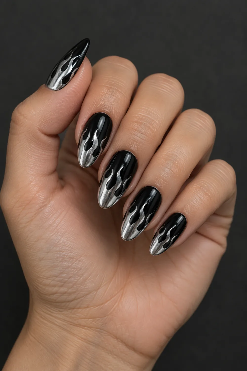 Glossy black almond nails with silver chrome flames