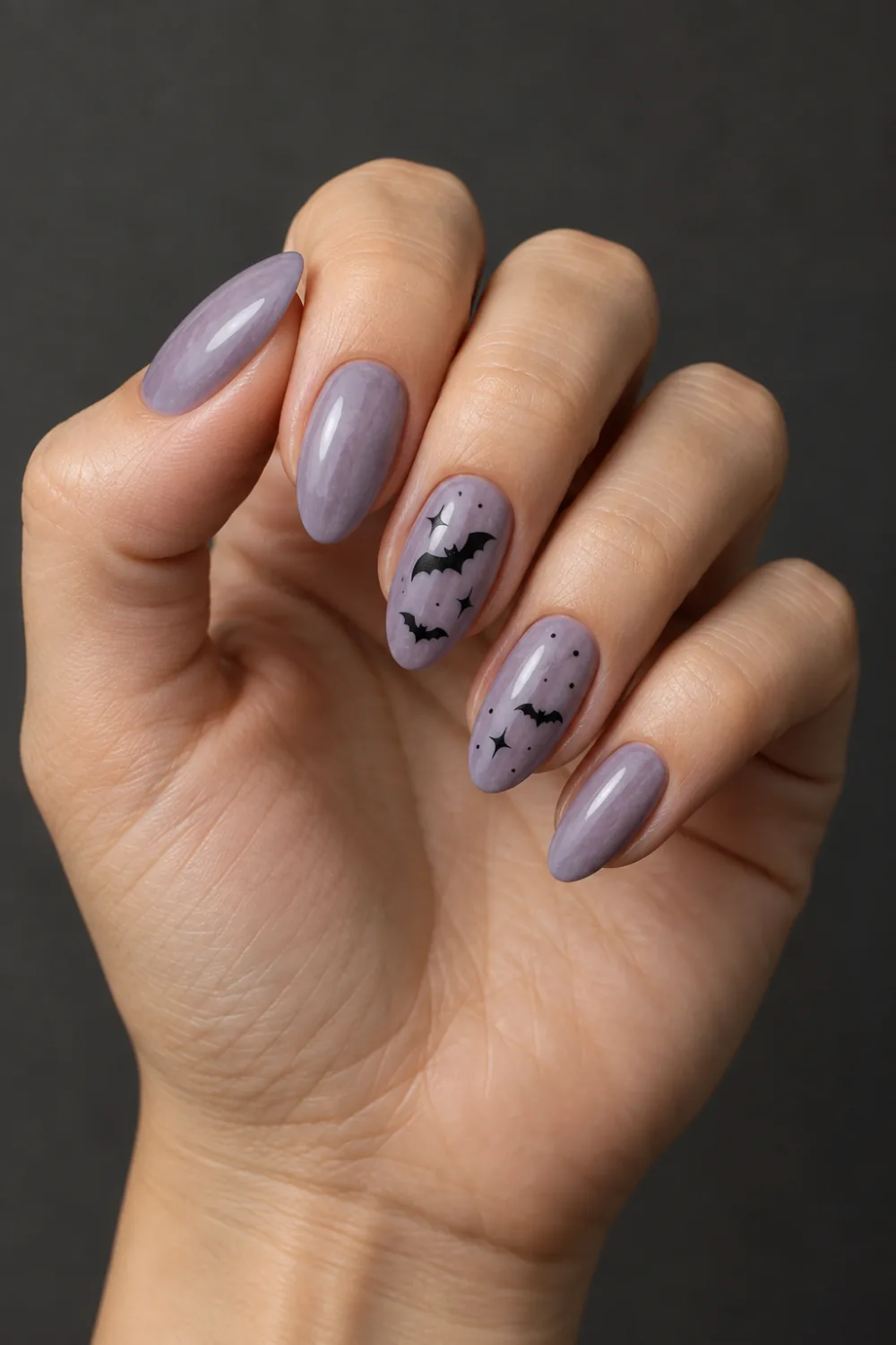 Dusty lavender nails with small black bat and star accents