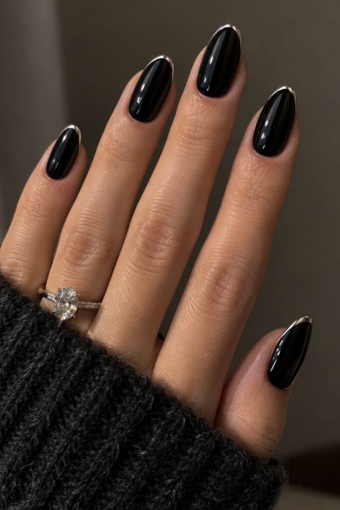 Glossy black gel nails with a thin silver chrome French edge